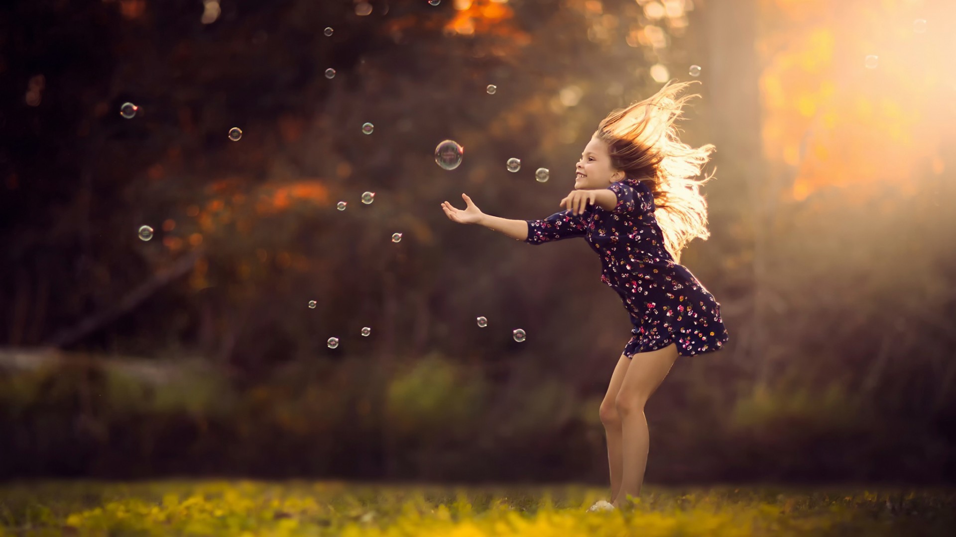 Девочка играет с мыльными пузырями