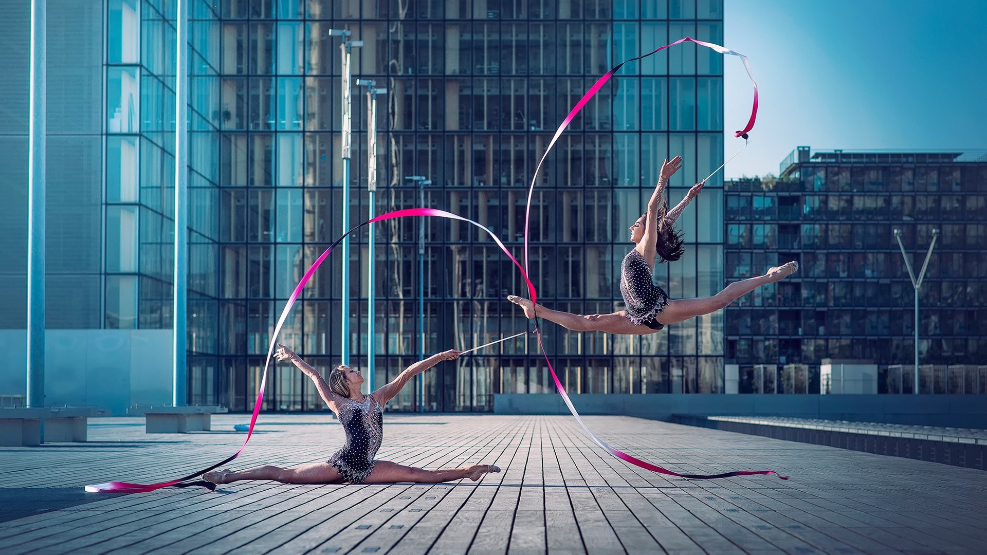Гимнастки с лентами на площади перед небоскребом