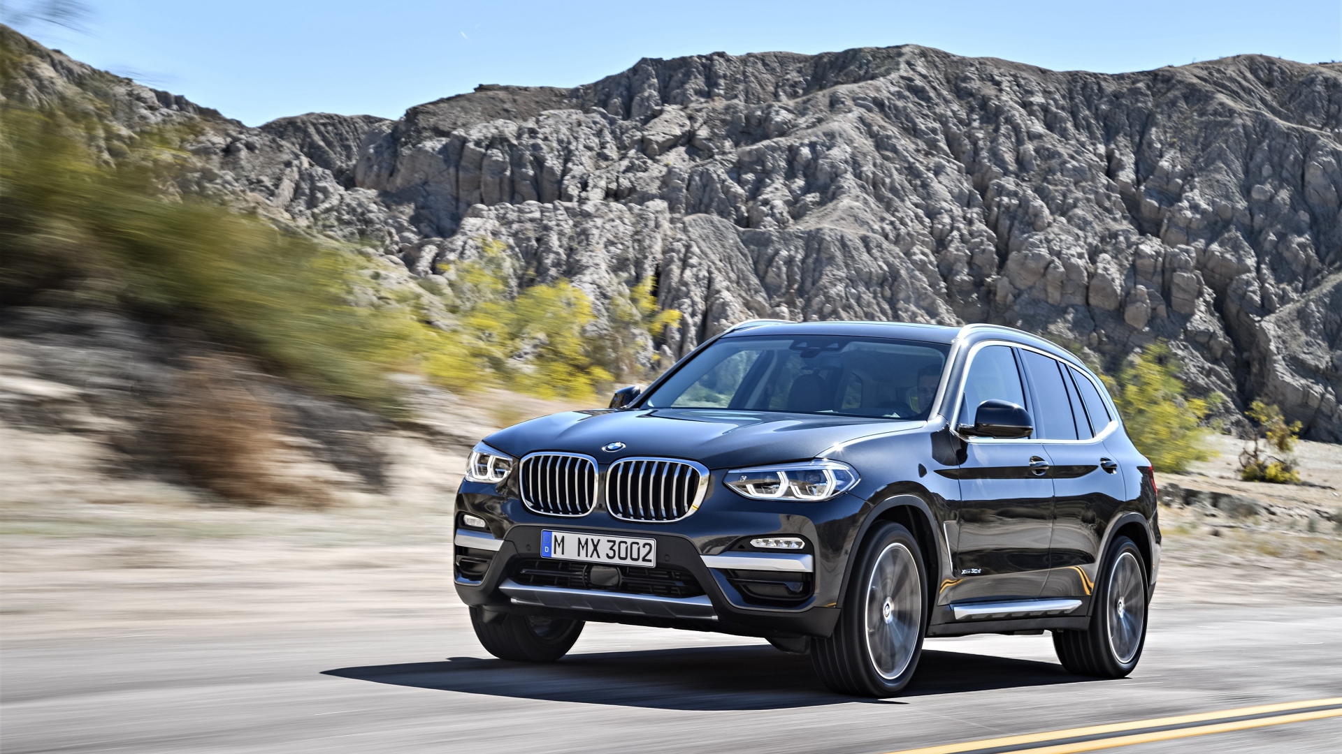 Черный красивый автомобиль BMW X3, 2018 на фоне гор