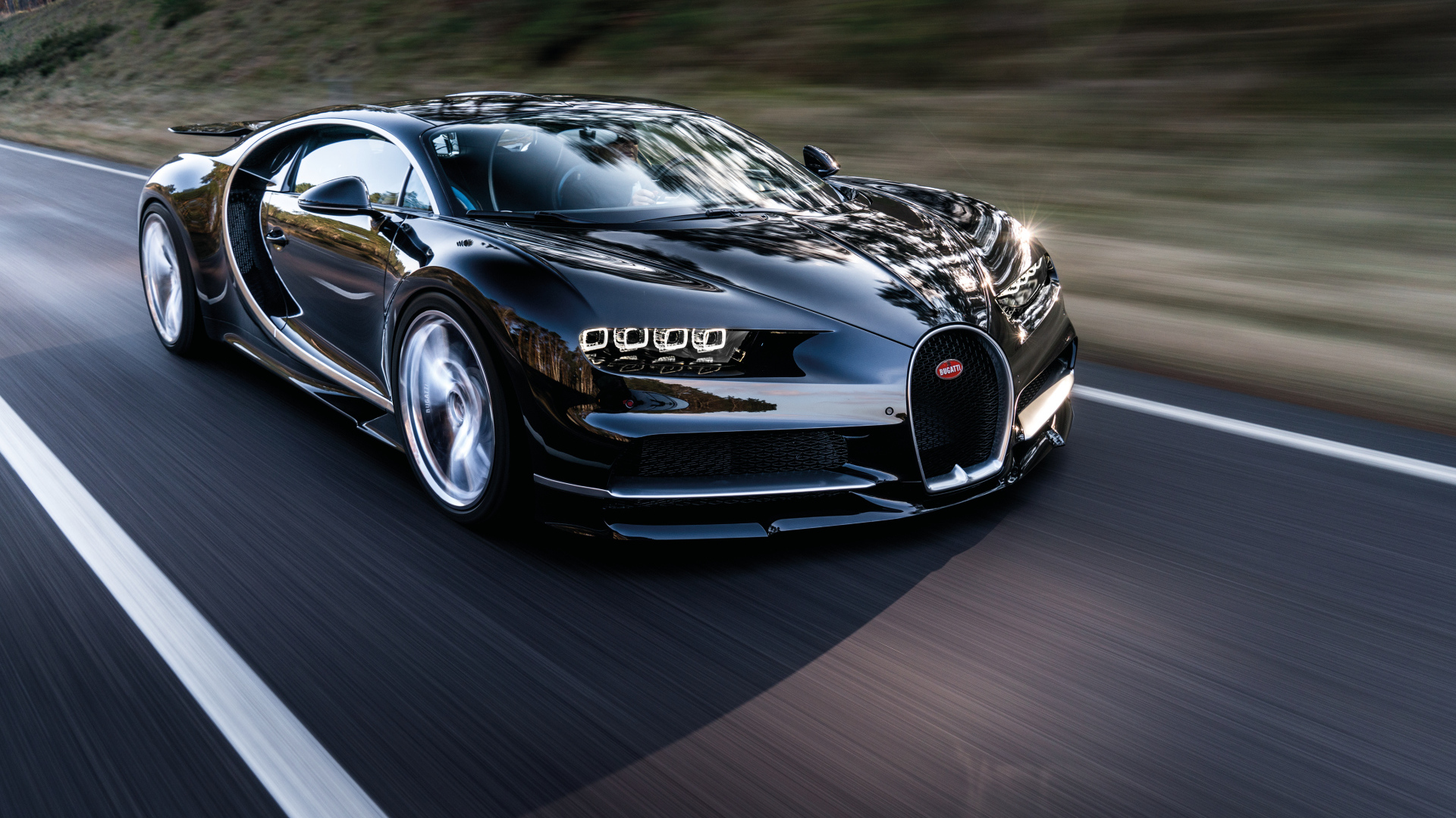 Черный быстрый автомобиль Bugatti Chiron на трассе