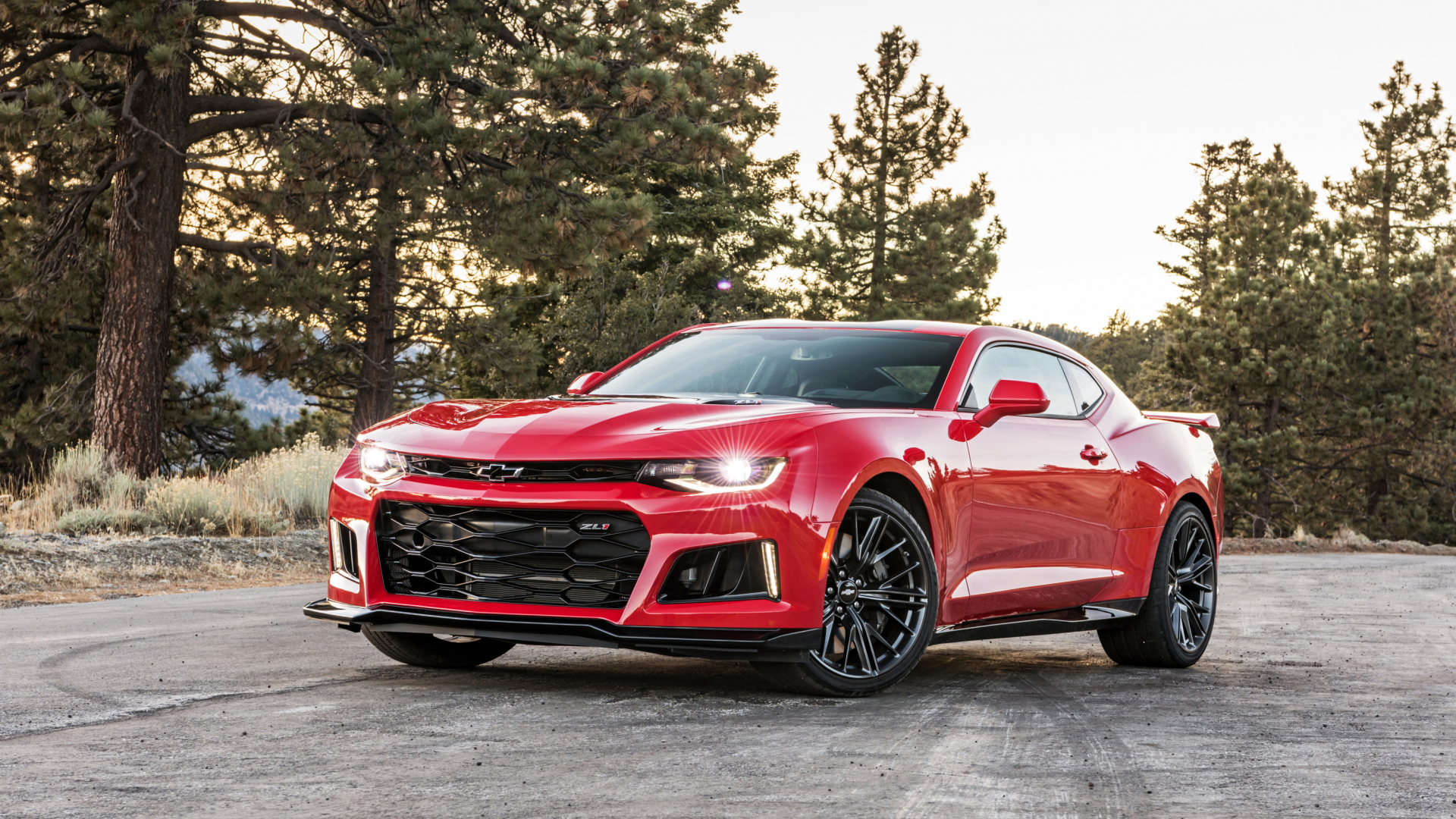 Красный автомобиль Chevrolet Camaro ZL1 на фоне леса 