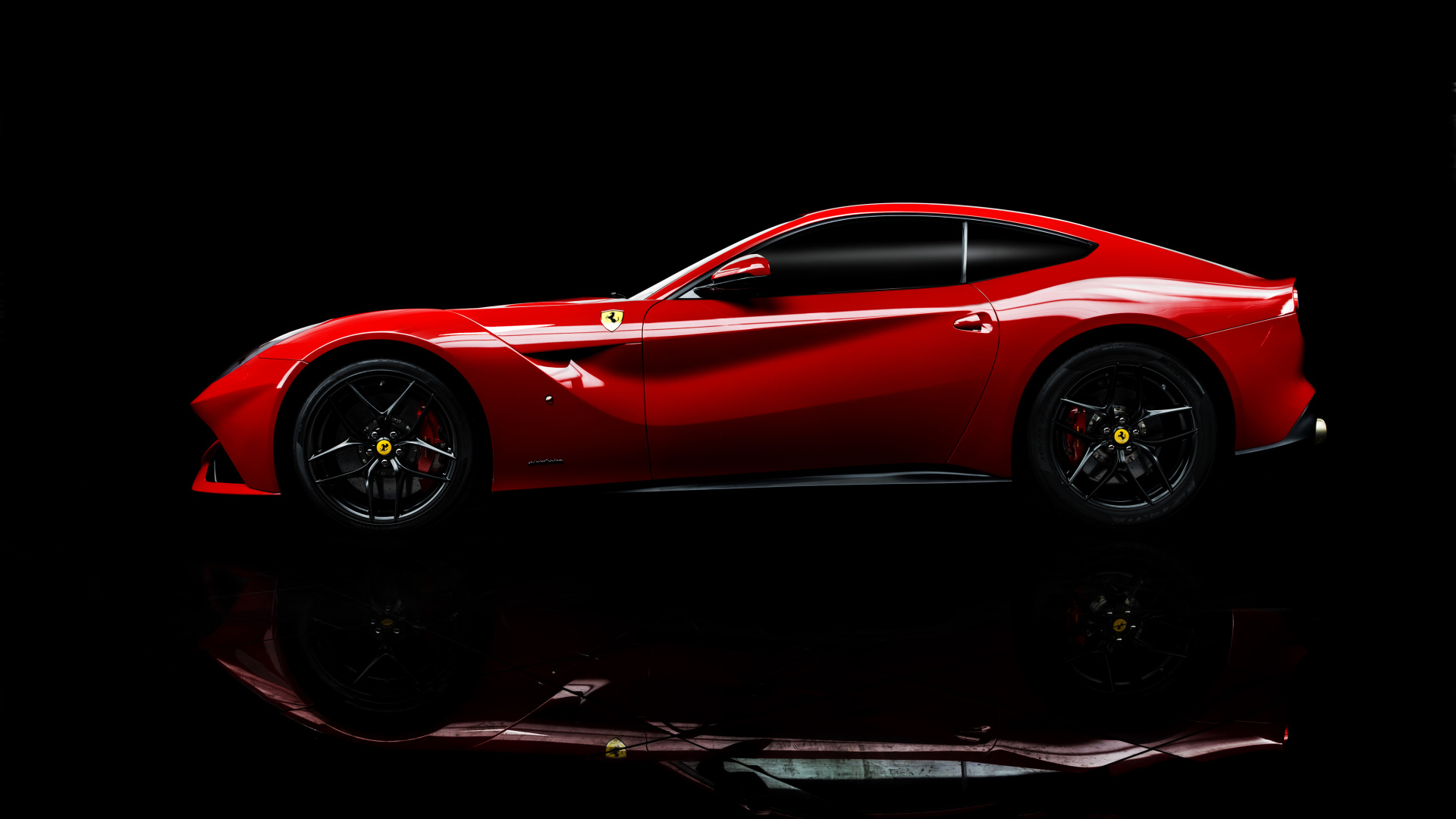 Красный спортивный автомобиль Ferrari F12 berlinetta на черном фоне