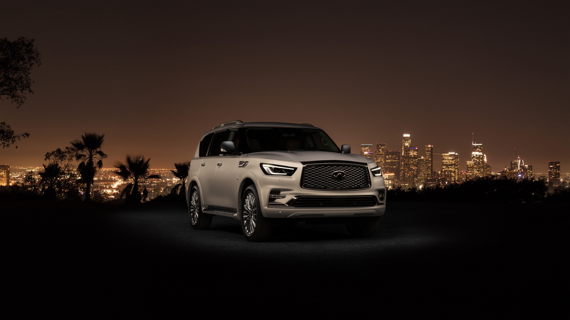 Автомобиль Infiniti QX80 2018 на фоне ночного города