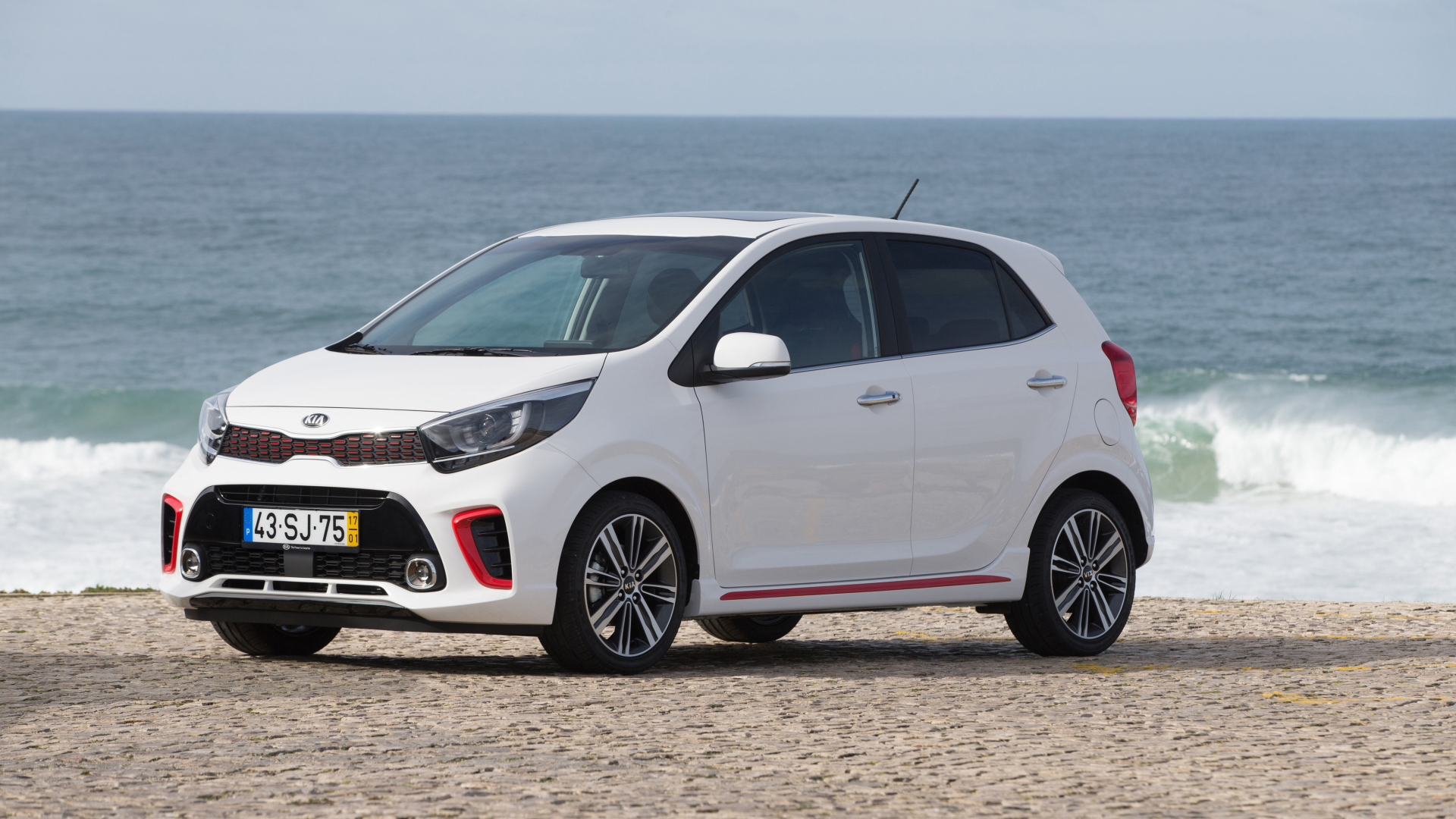 Белый автомобиль KIA Picanto GT Line, 2017 на фоне океана 