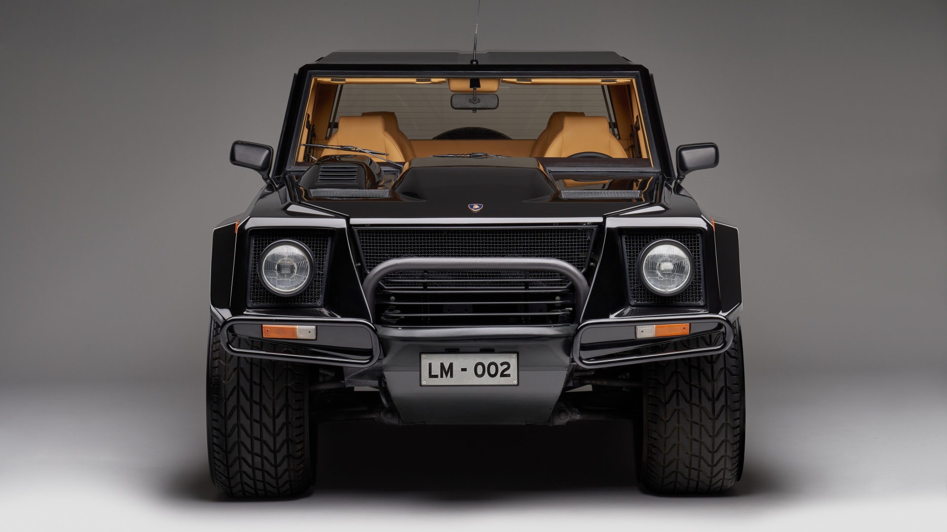 Черный автомобиль Lamborghini LM002 на сером фоне