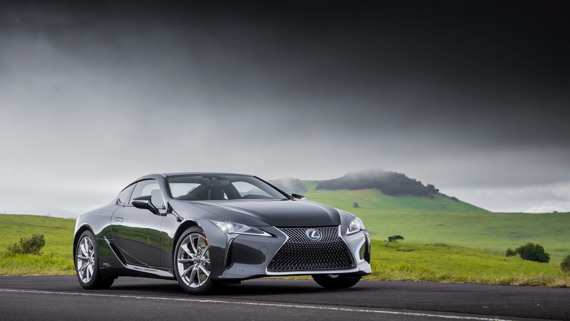 Серебристый автомобиль Lexus LC 500h, 2018 под грозовым небом