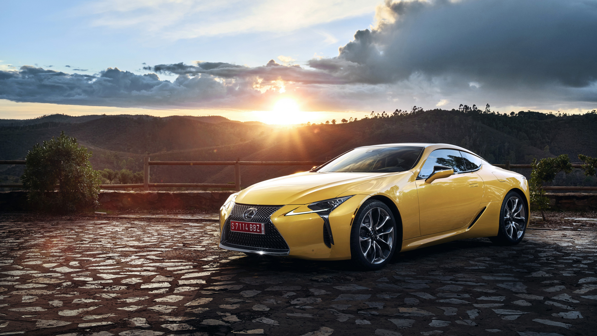 Желтый автомобиль Lexus LC 500  на фоне заката 
