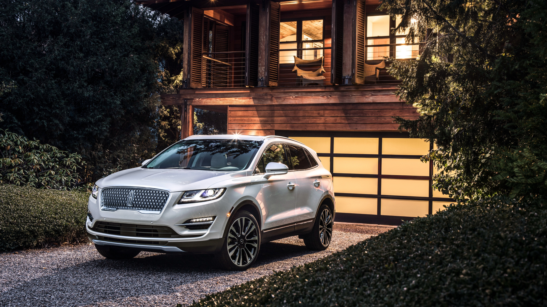 Серебристый автомобиль Lincoln MKC, 2019 у ворот гаража