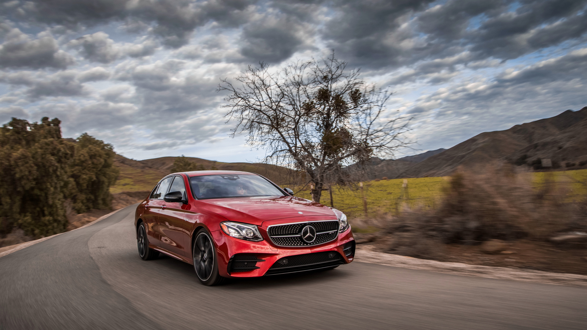 Стильный красный автомобиль Mercedes-Benz E-Class на фоне неба 