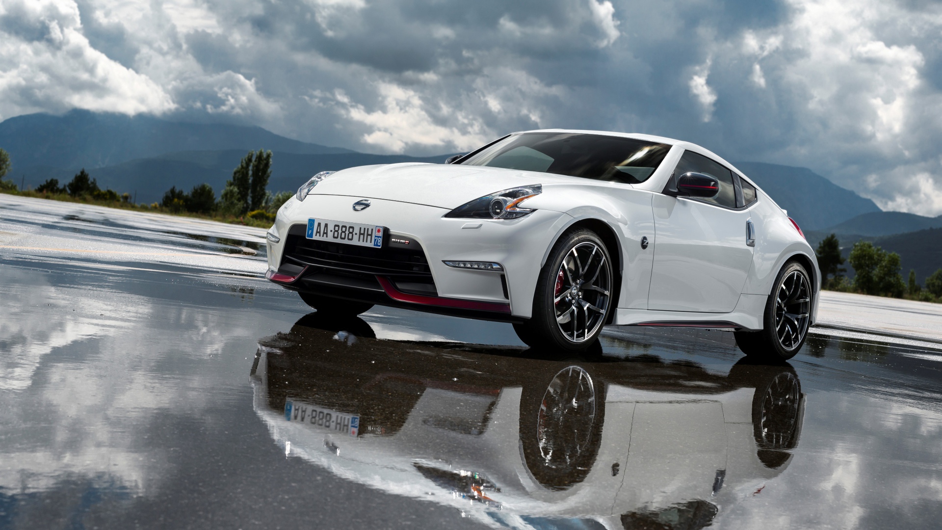 Белый автомобиль Nissan 370z Nismo, 2018 на фоне пасмурного неба