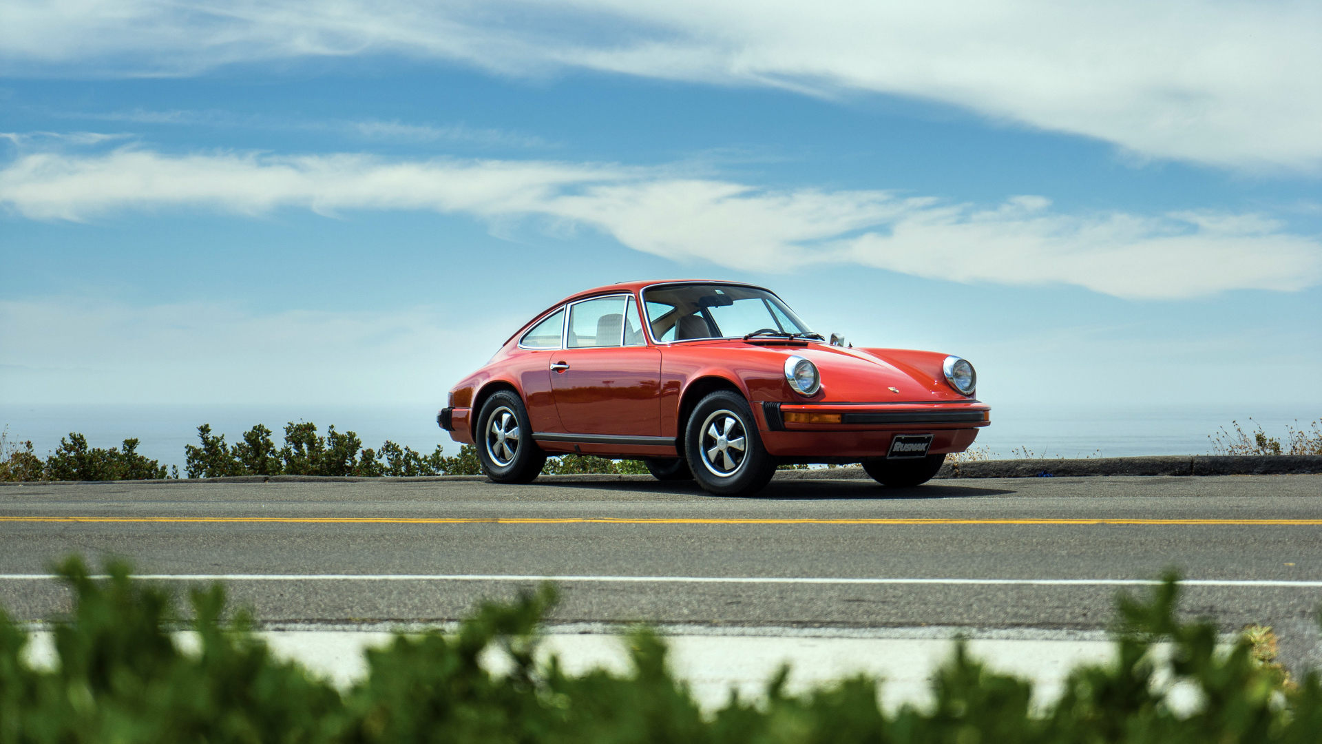 Красный автомобиль Porsche 912 на фоне голубого неба 