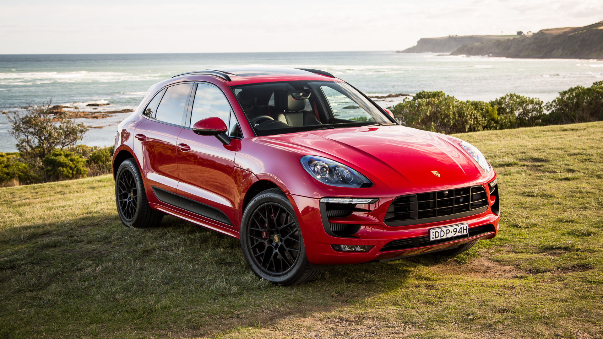 Красный автомобиль Porsche Macan,2017 на фоне океана 