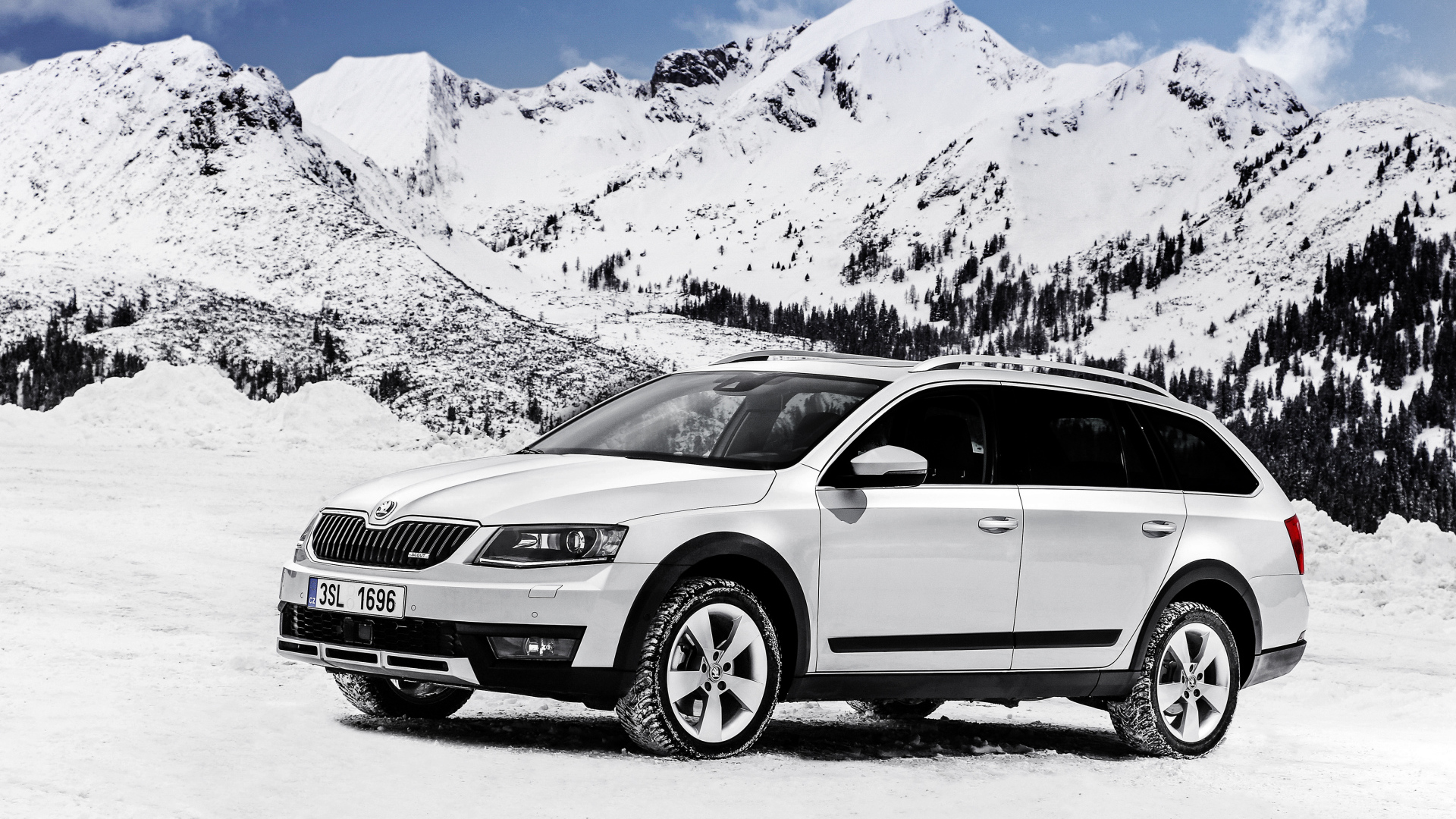 Белый автомобиль Skoda Octavia на фоне заснеженных гор
