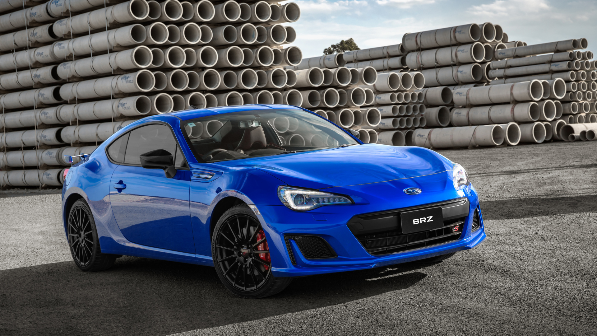 Синий автомобиль Subaru BRZ tS, 2018 на фоне труб