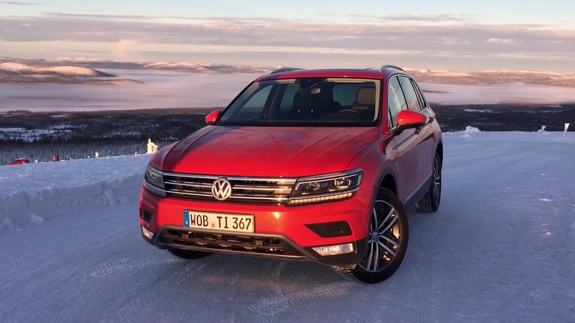 Красный Volkswagen Tiguan 2017 года на заснеженной трассе 