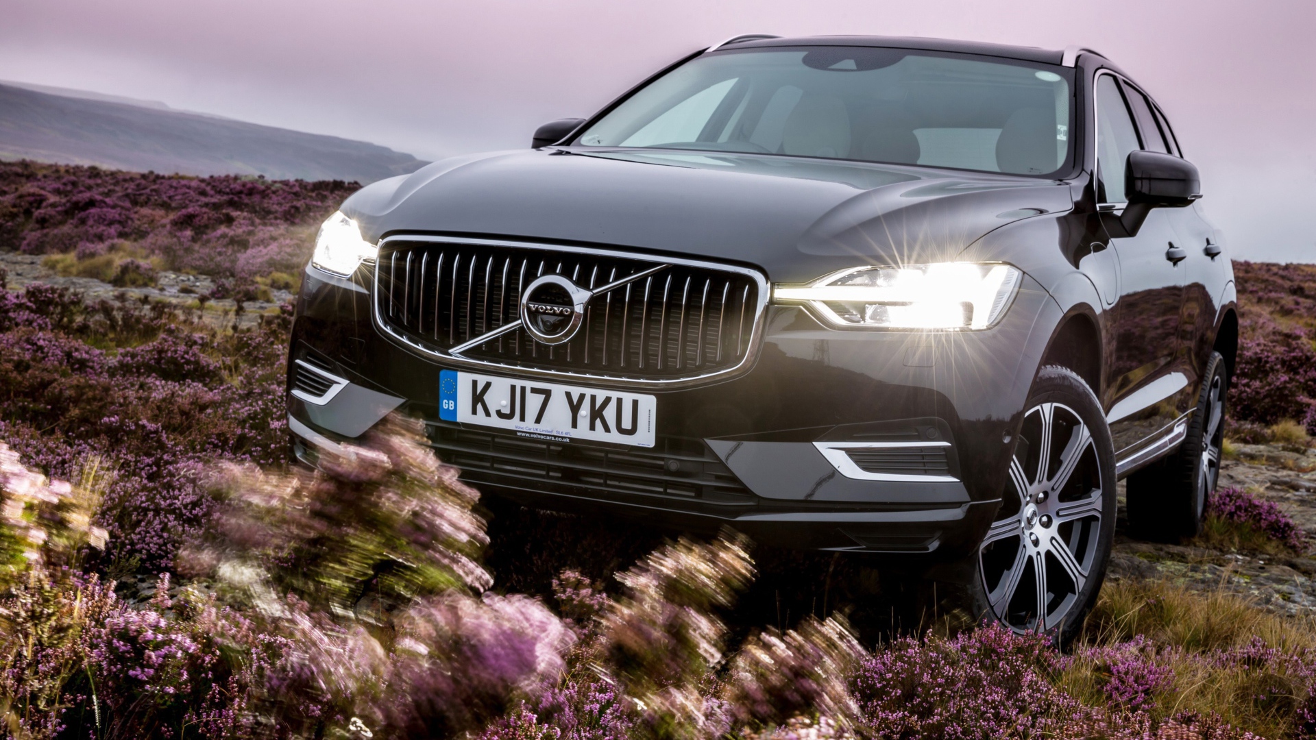 Черный автомобиль Volvo XC60 T8, 2018 с включенными фарами