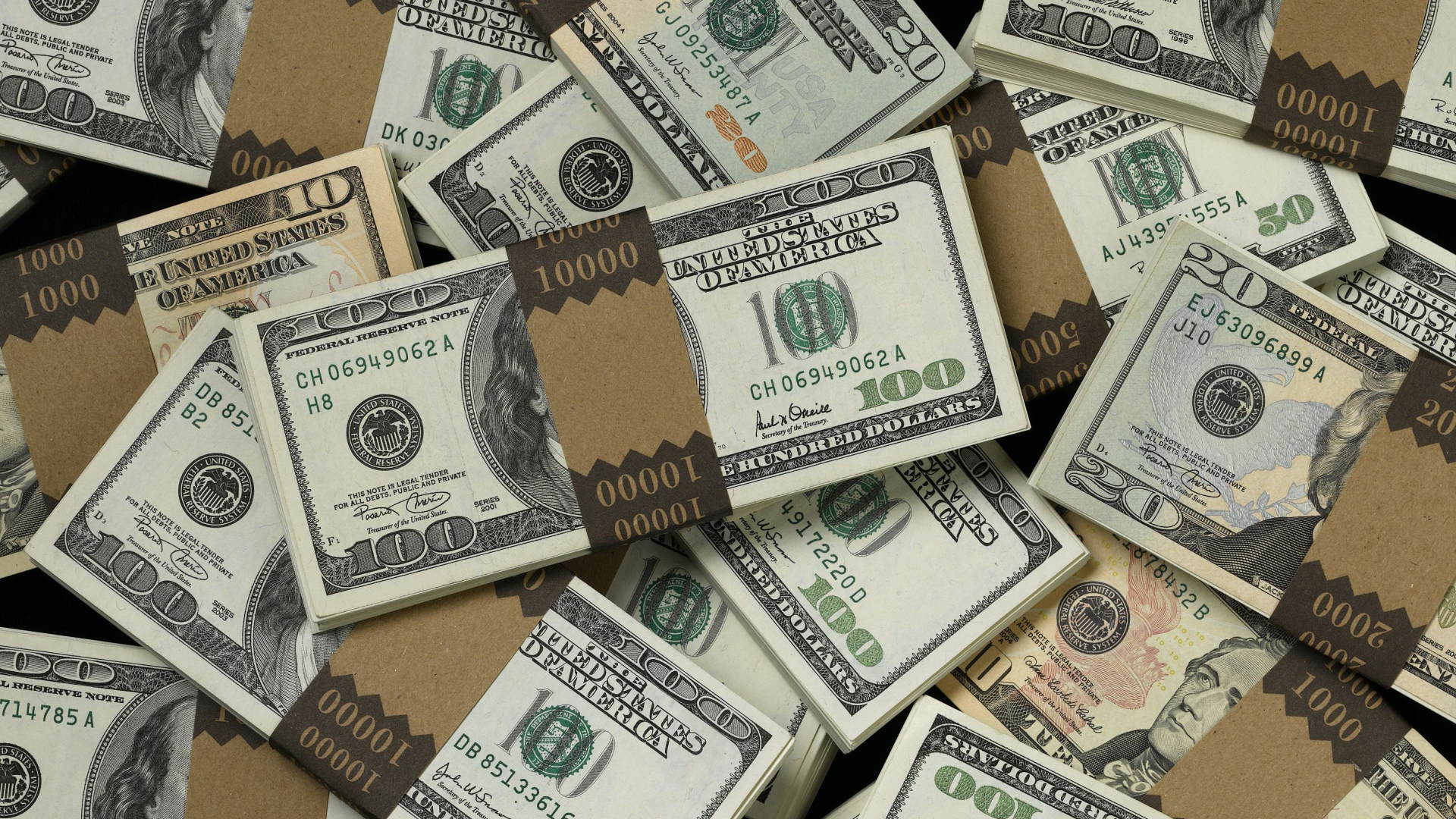 Много пачек купюр по сто долларов