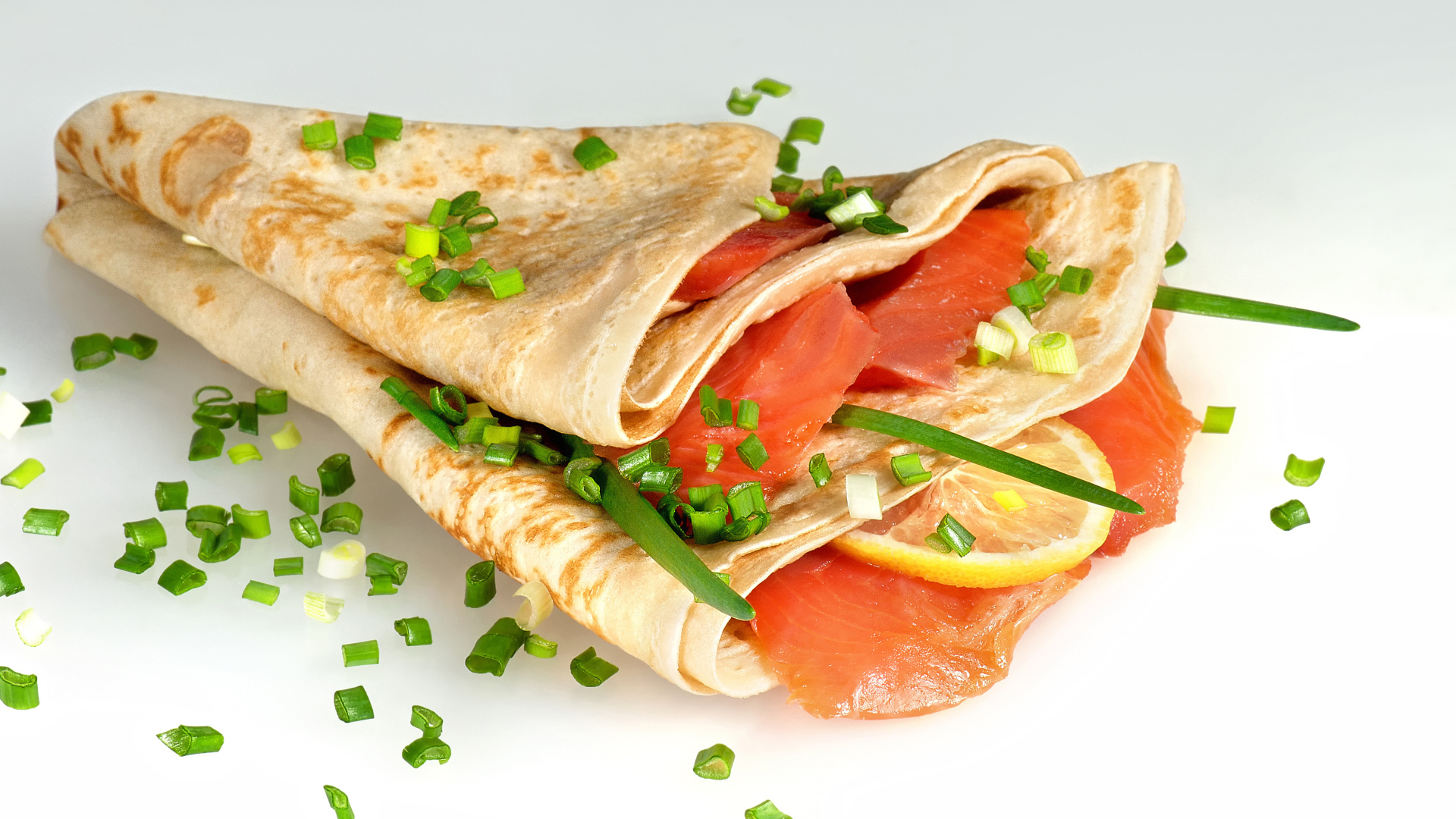 Аппетитный блин с красной рыбой и зеленым луком