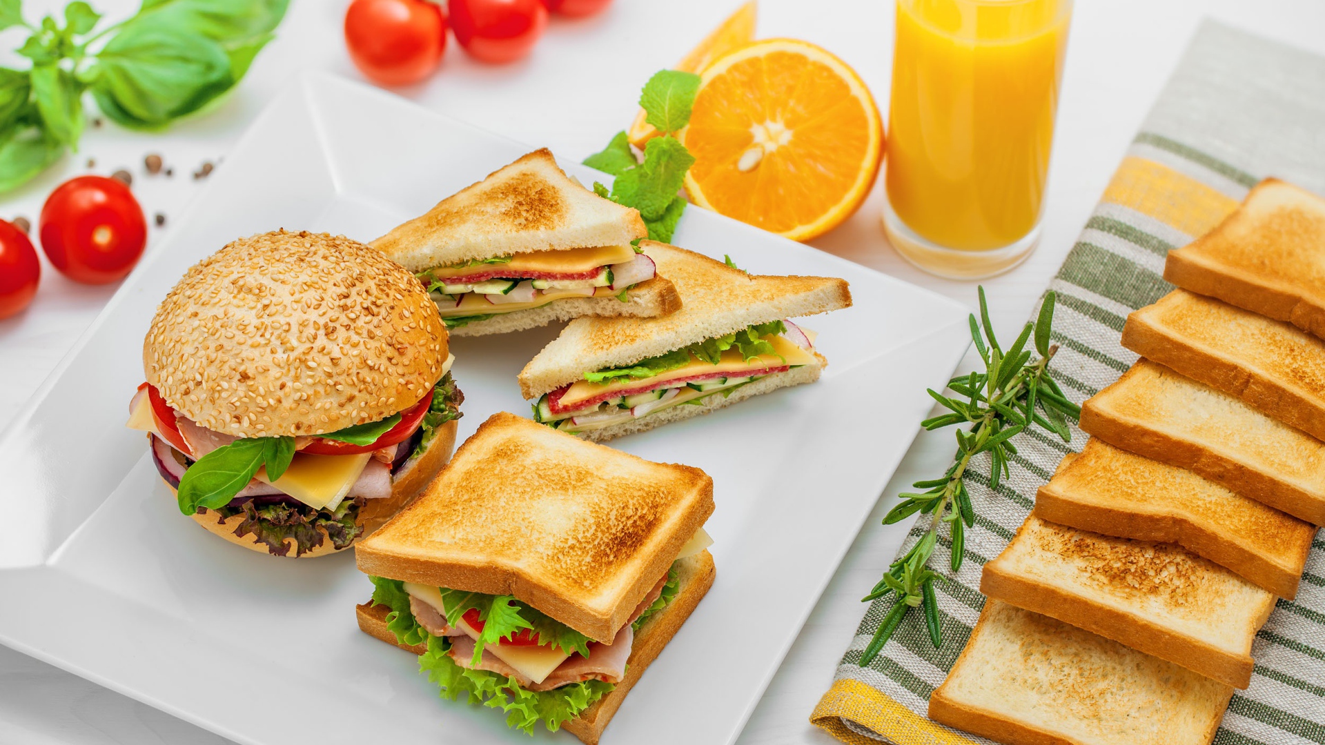 Гамбургер и сендвичи на столе с апельсиновым соком
