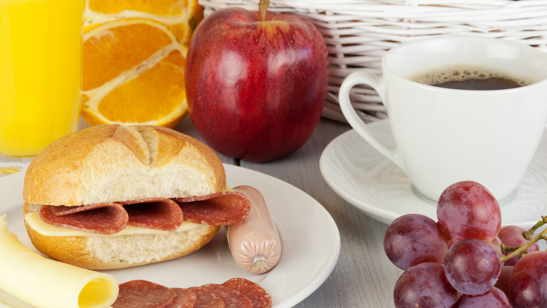 Бутерброд с сыром и колбасой и сок с яблоком и виноградом на завтрак