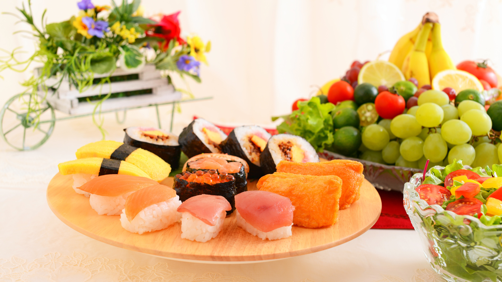 Суши на столе с фруктами и салатом из овощей