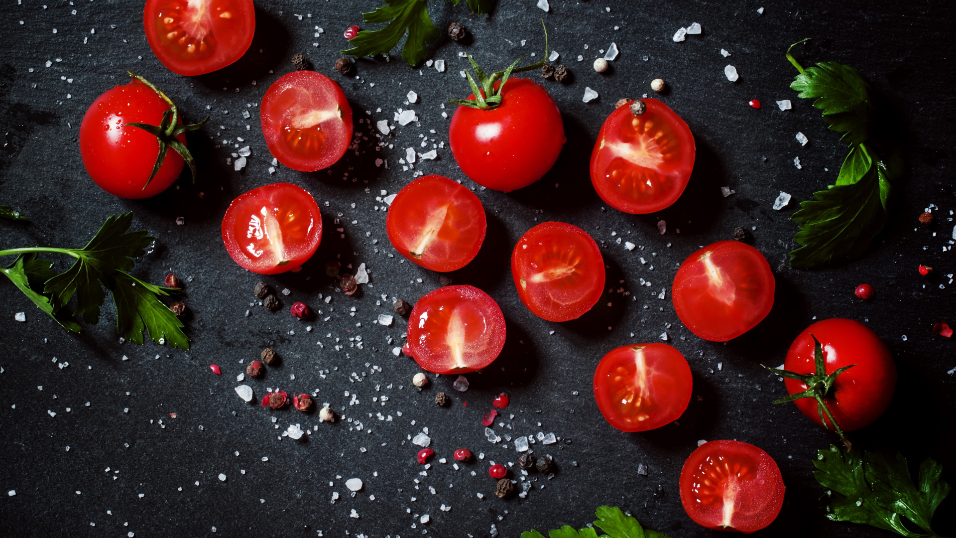 Помидоры на столе с зеленью петрушки и специями