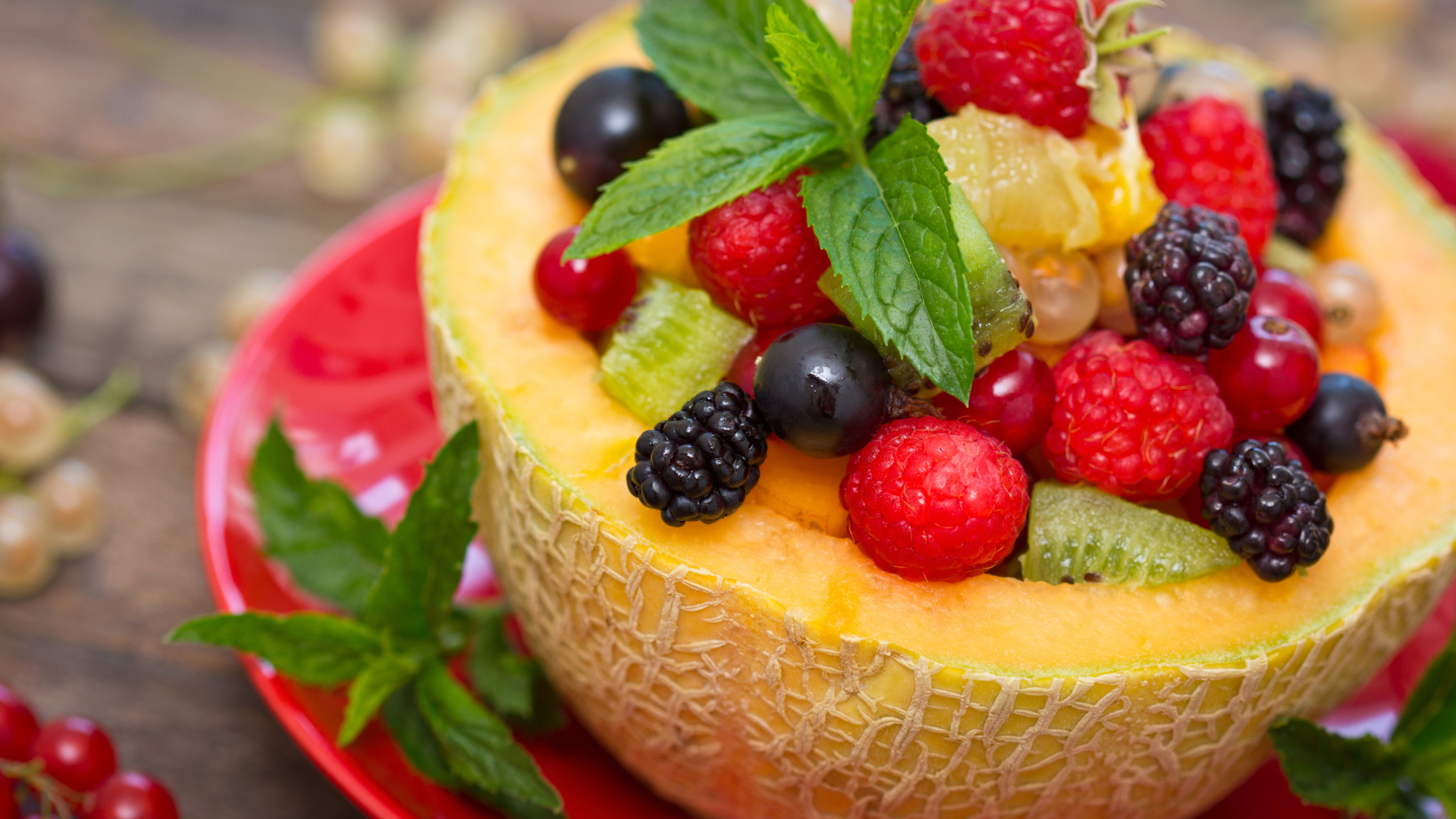 Аппетитные свежие ягоды с листьями мяты в половине дыни