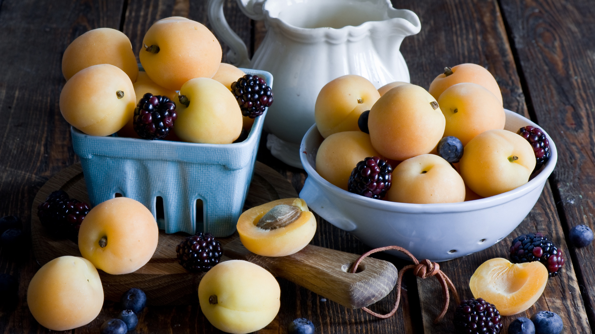 Спелые абрикосы и ягоды на столе 