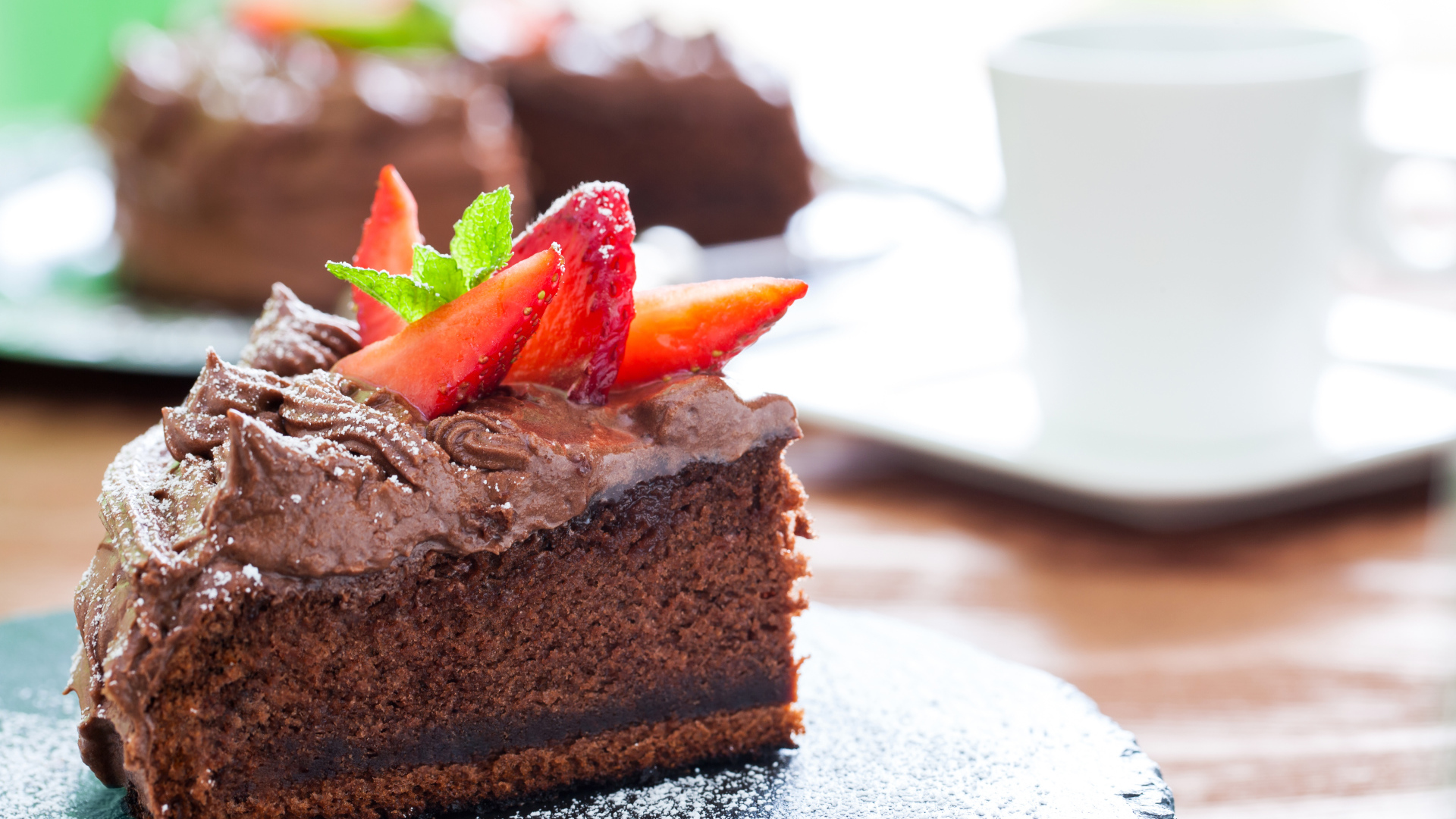 Кусок шоколадного торта с кремом и свежей клубникой 