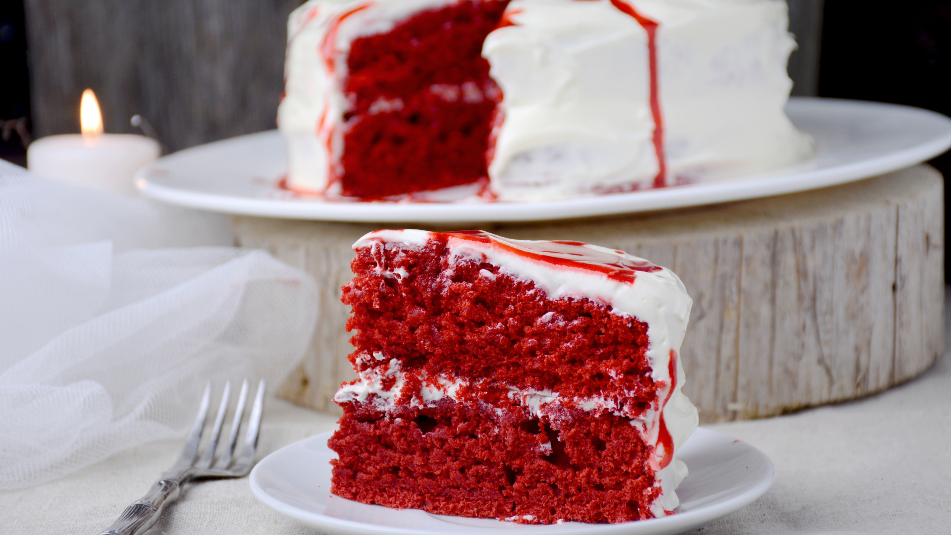 Кусок торта красного цвета с белым кремом 