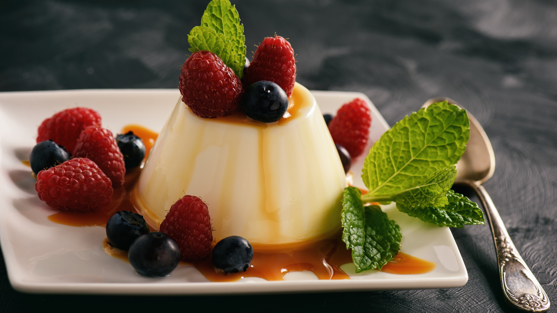 Аппетитный десерт с ягодами клубники и черники на белой тарелке