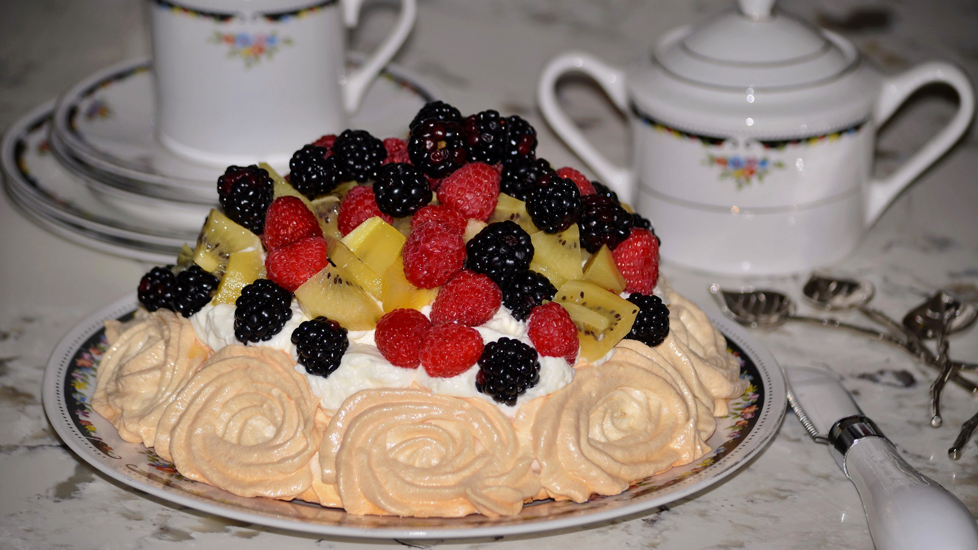 Торт с безе и свежими ягодами на столе 