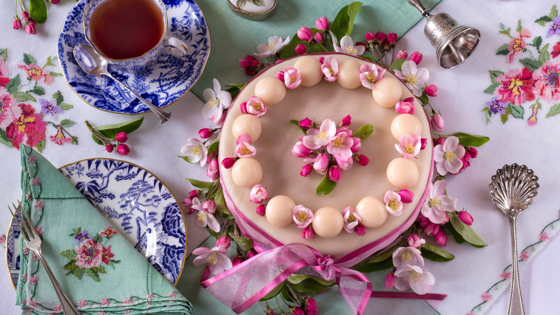 Торт с розовыми цветами на столе с красивым сервизом 