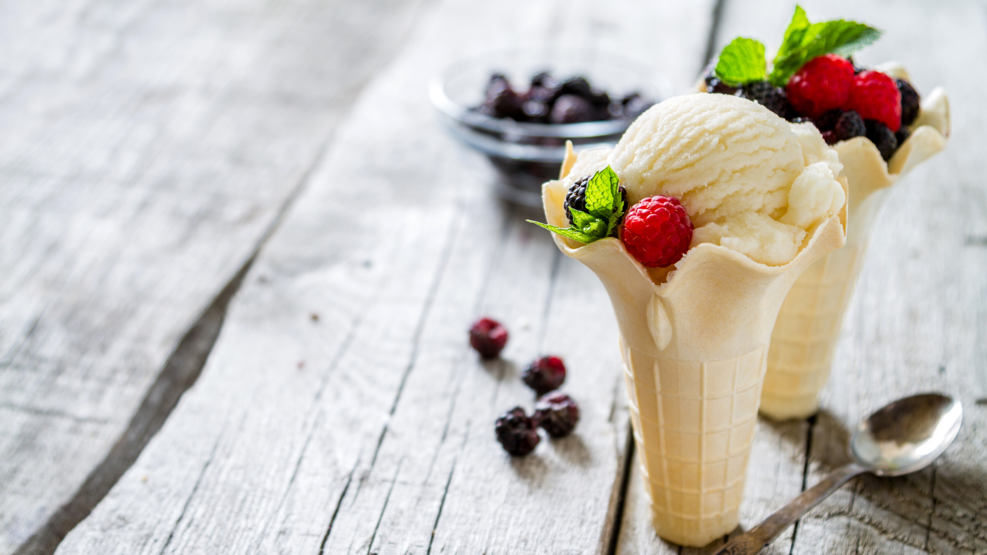 Сливочное мороженое в вафельном стаканчике с ягодами