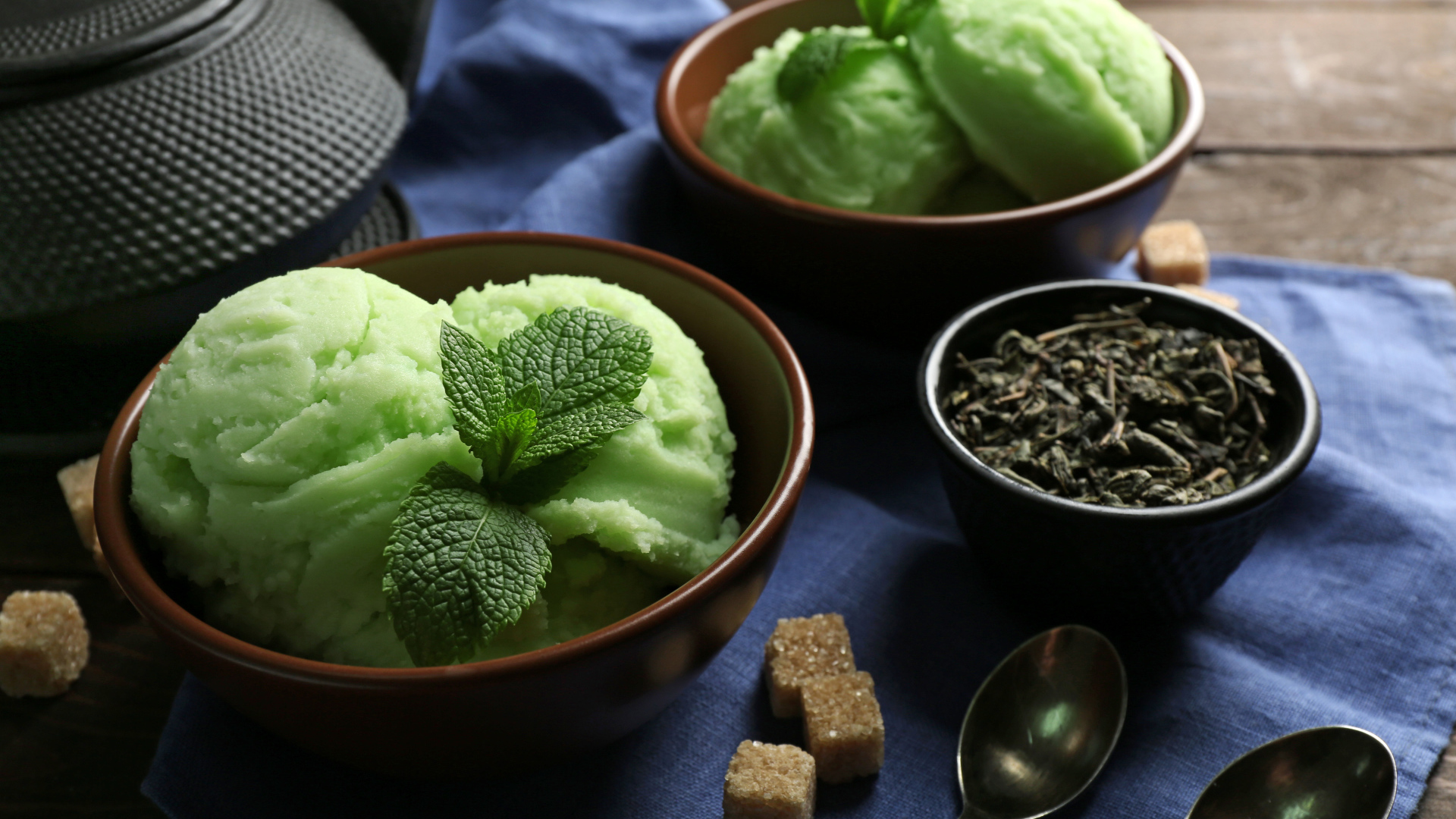 Зеленое мятное мороженое и кусочки сахара на столе 