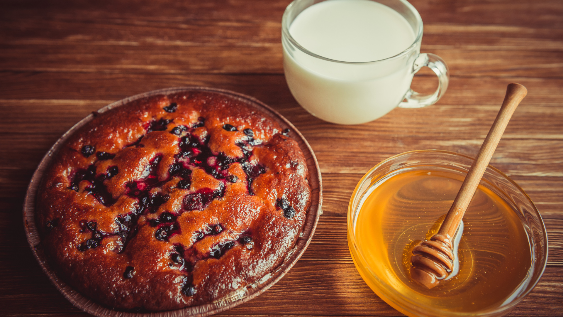 Пирог с ягодами, медом и молоком на столе