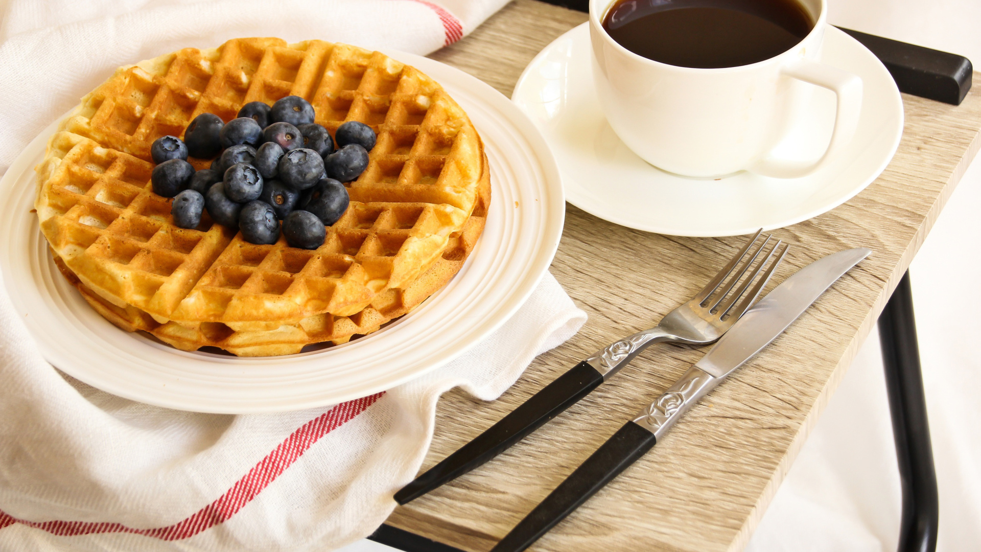 Сладкие вафли с черникой и чашкой кофе на завтрак