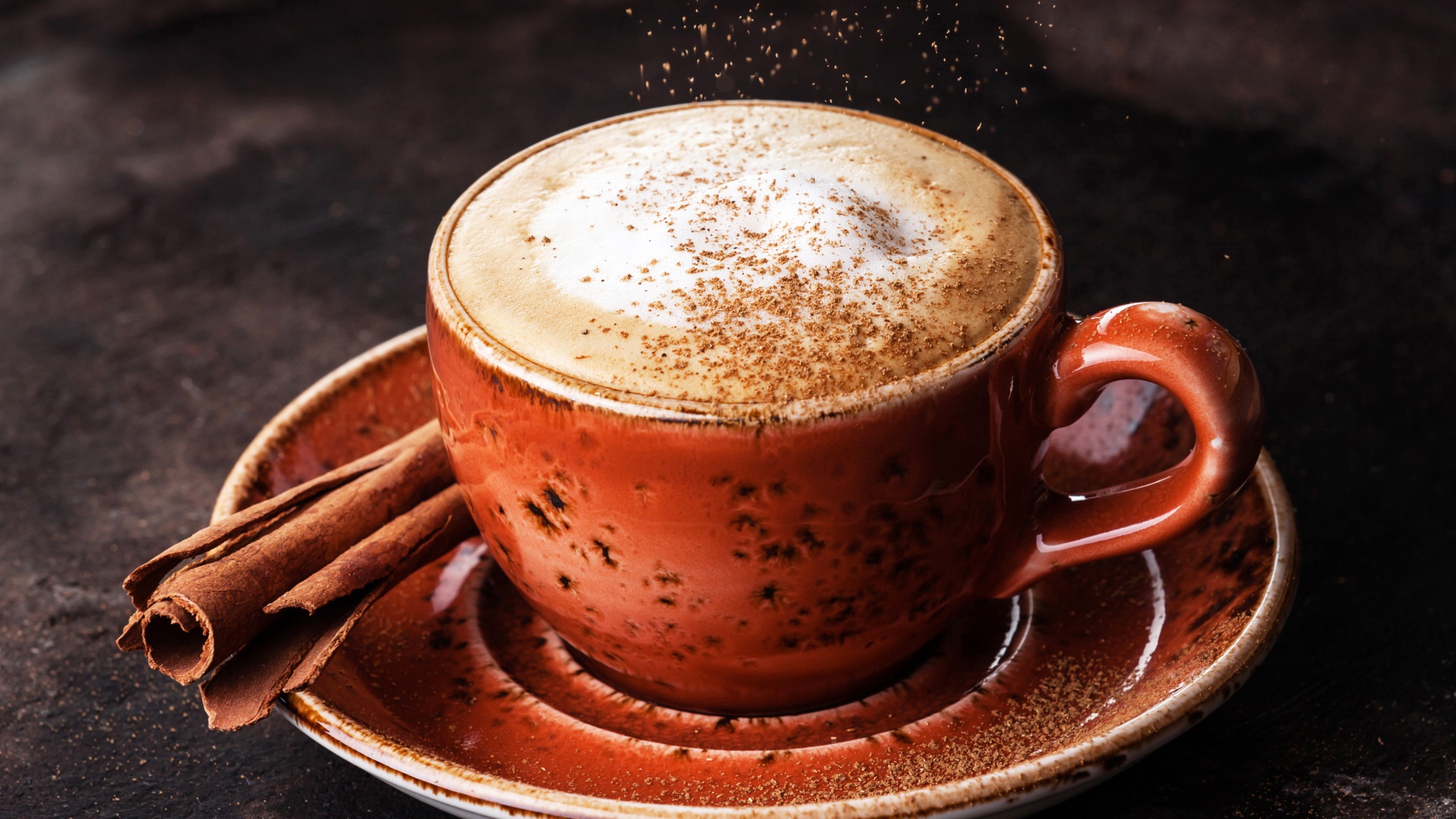 Чашка капучино с корицей на блюдце