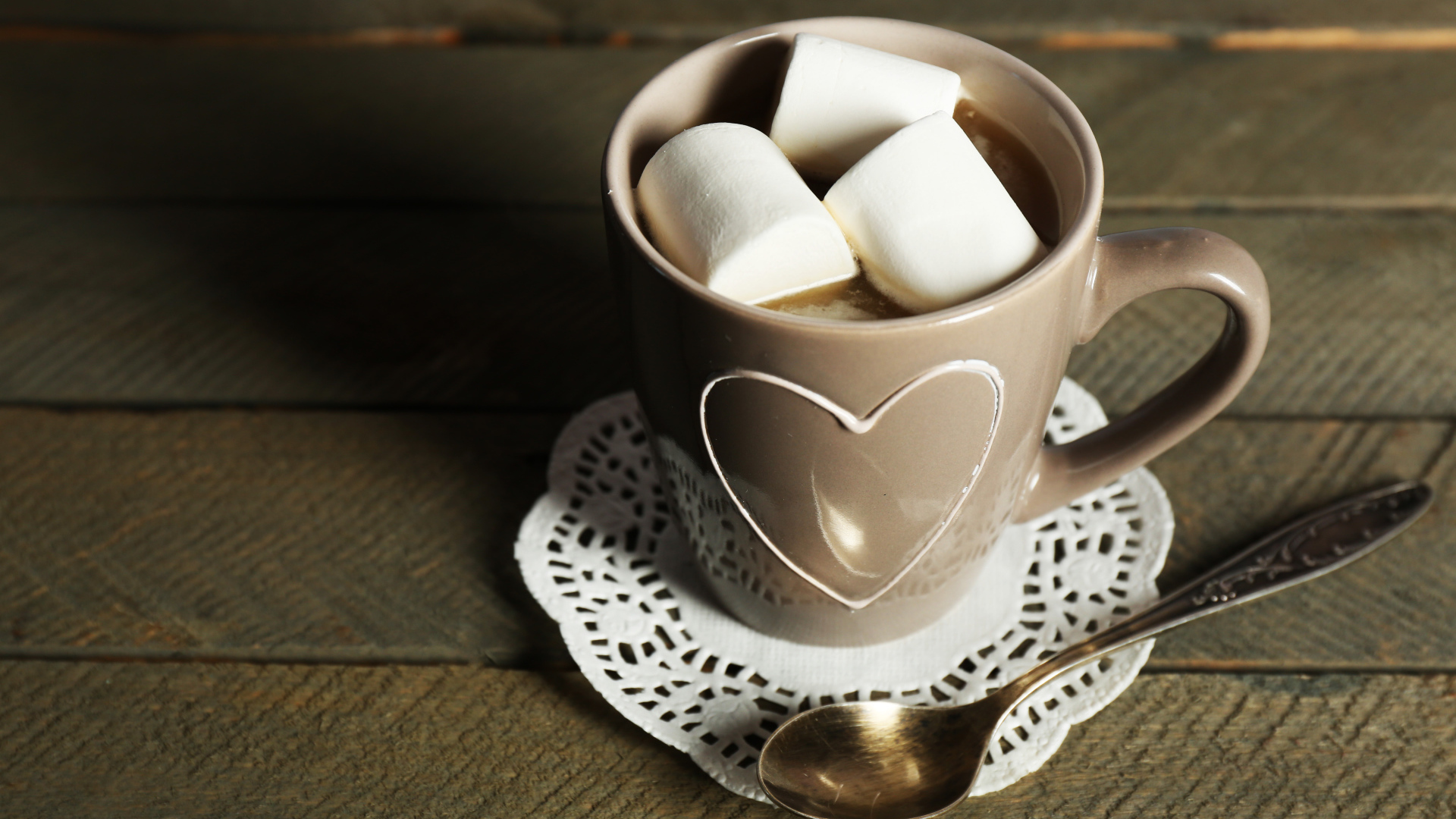 Чашка какао с кусочками маршмеллоу на кружевной салфетке