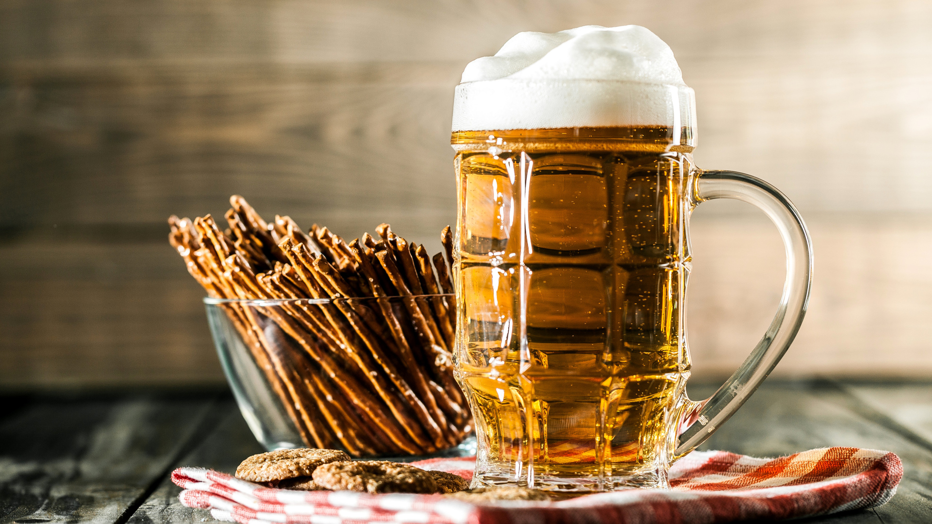 Бокал свежего пива с выпечкой на столе