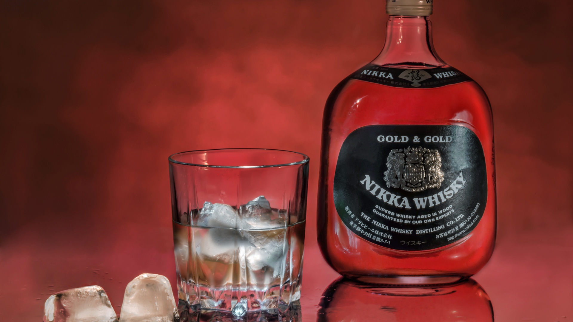 Бутылка Nikka Whisky на столе со стаканом со льдом