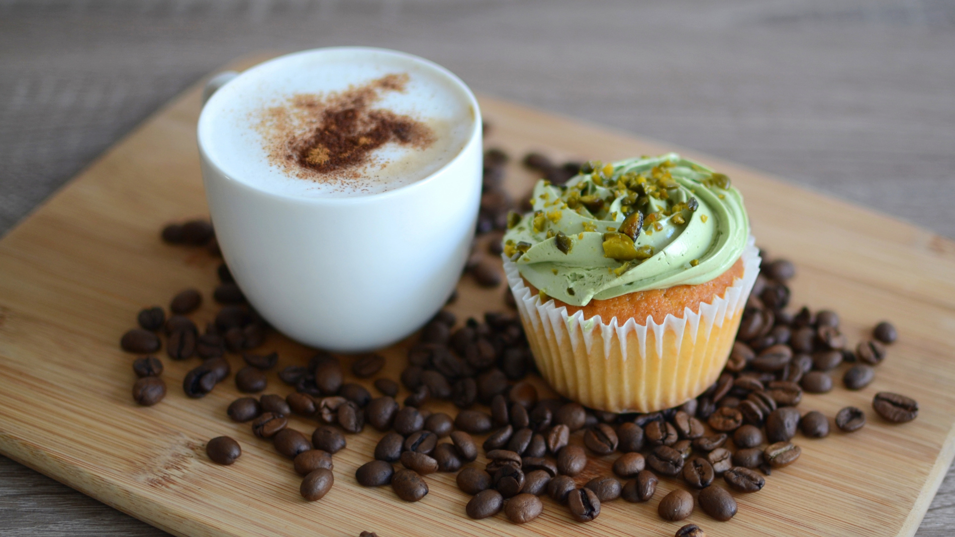 Кофе с аппетитным капкейком стоят на кофейных зернах