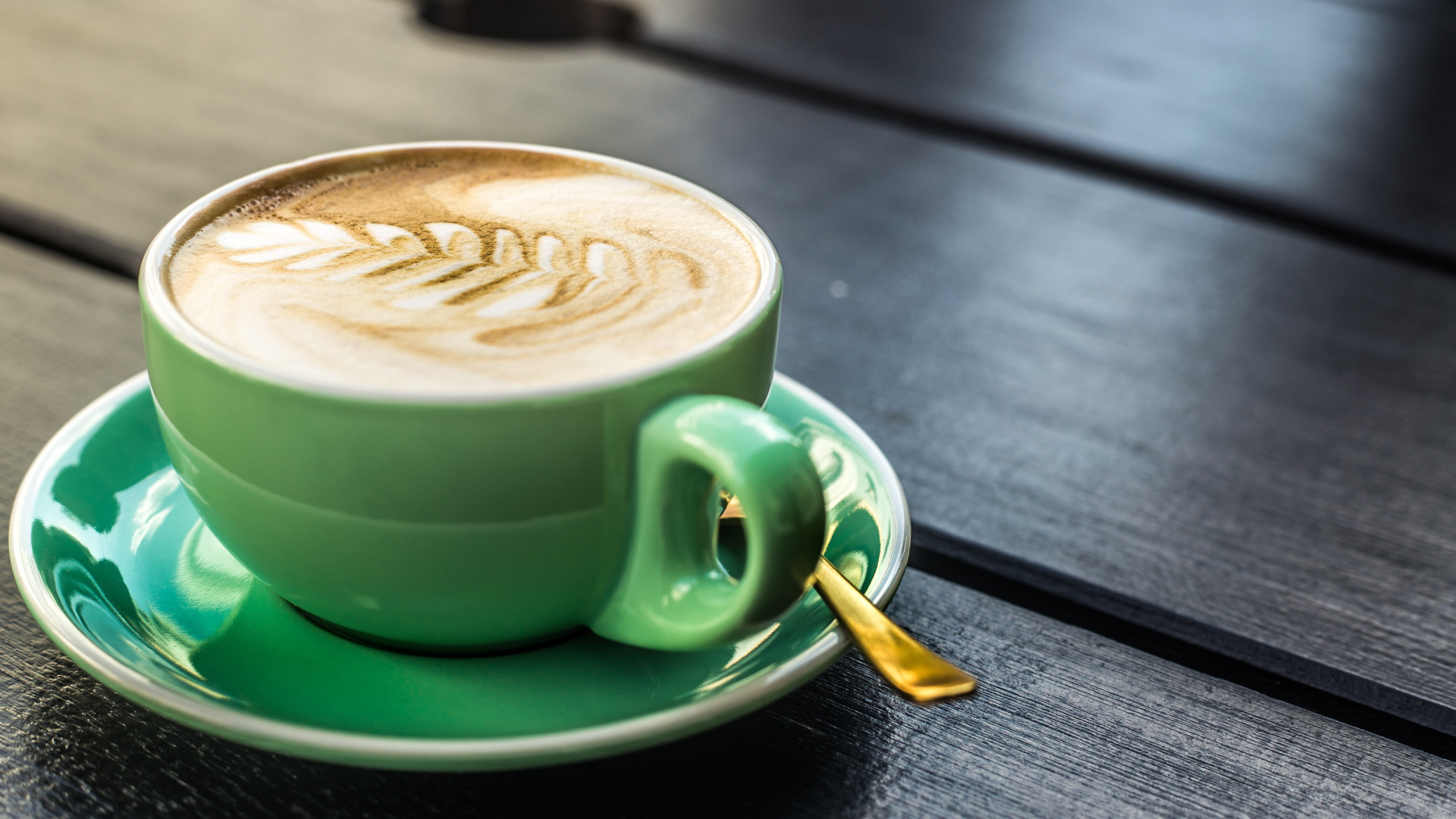 Зеленая чашка капучино с белой пенкой 