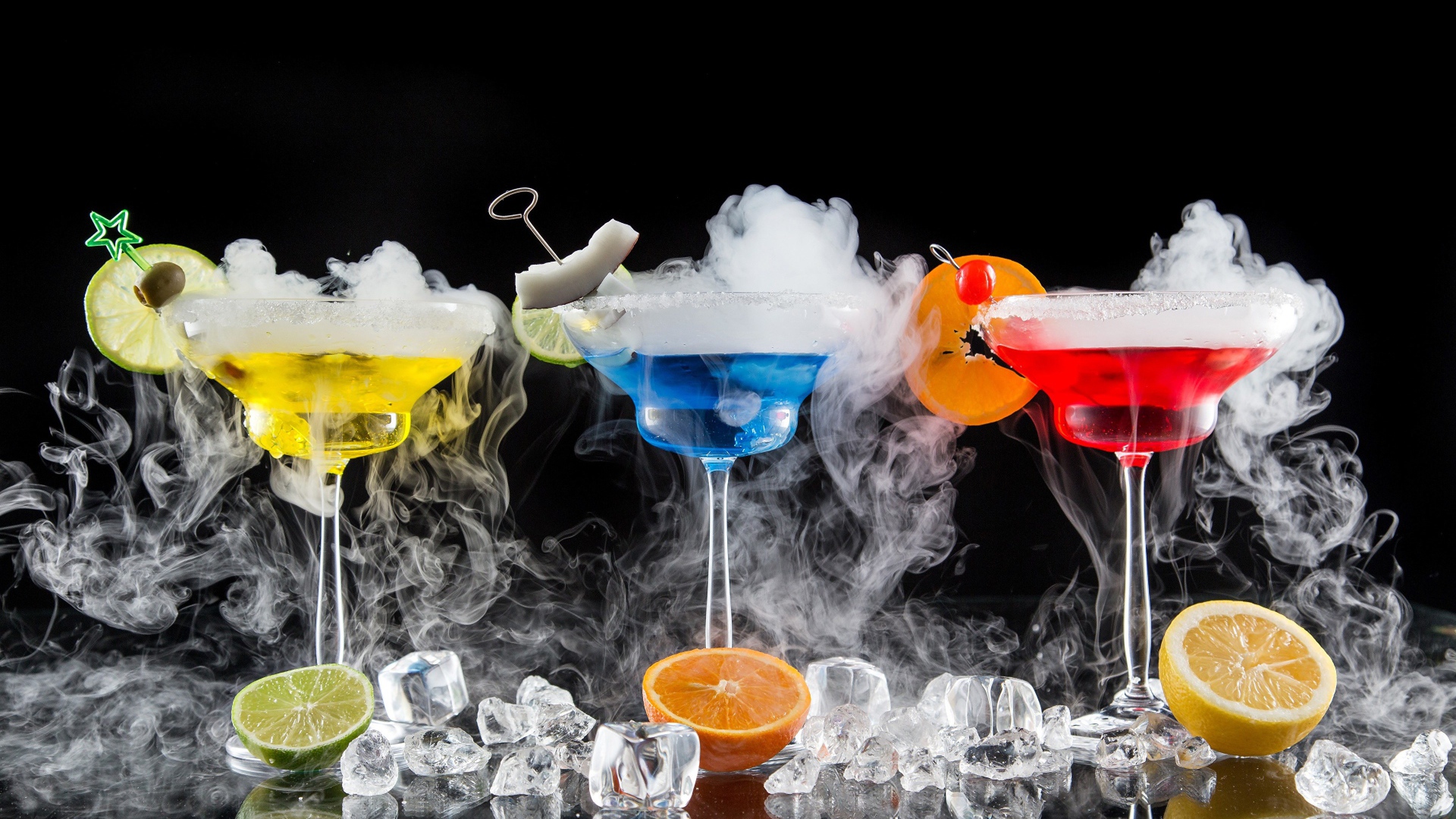 Три алкогольных коктейля с сухим льдом на черном фоне