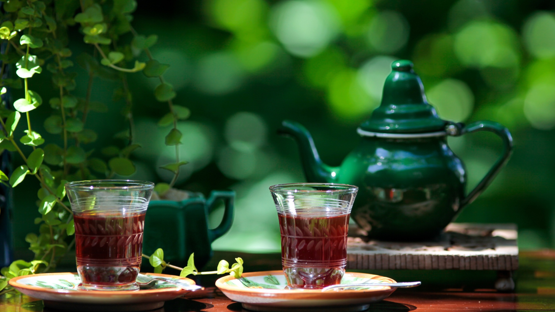 Две чашки чая и зеленый чайник на столе 