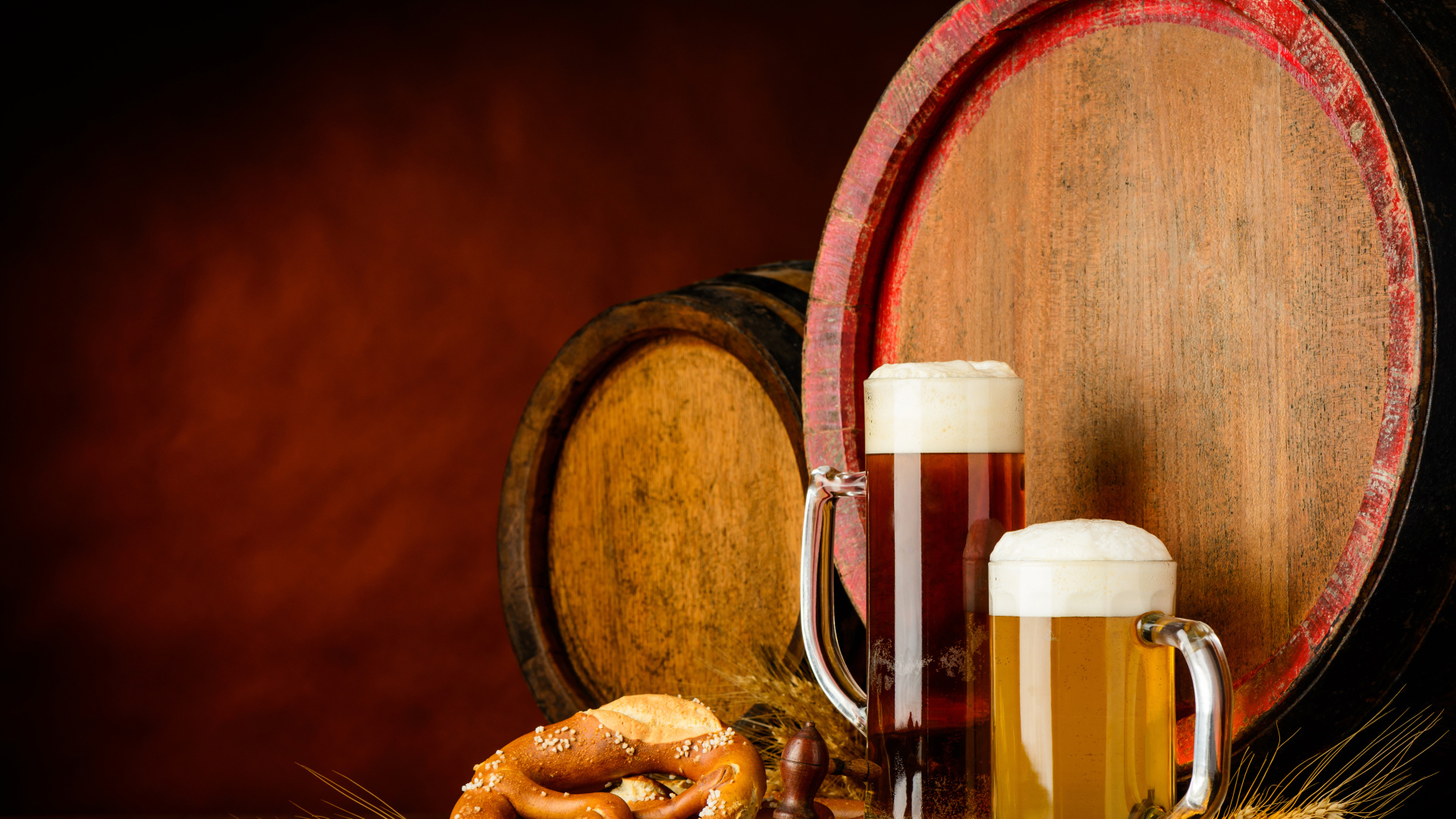 Два бокала пива и выпечка у пивных бочек