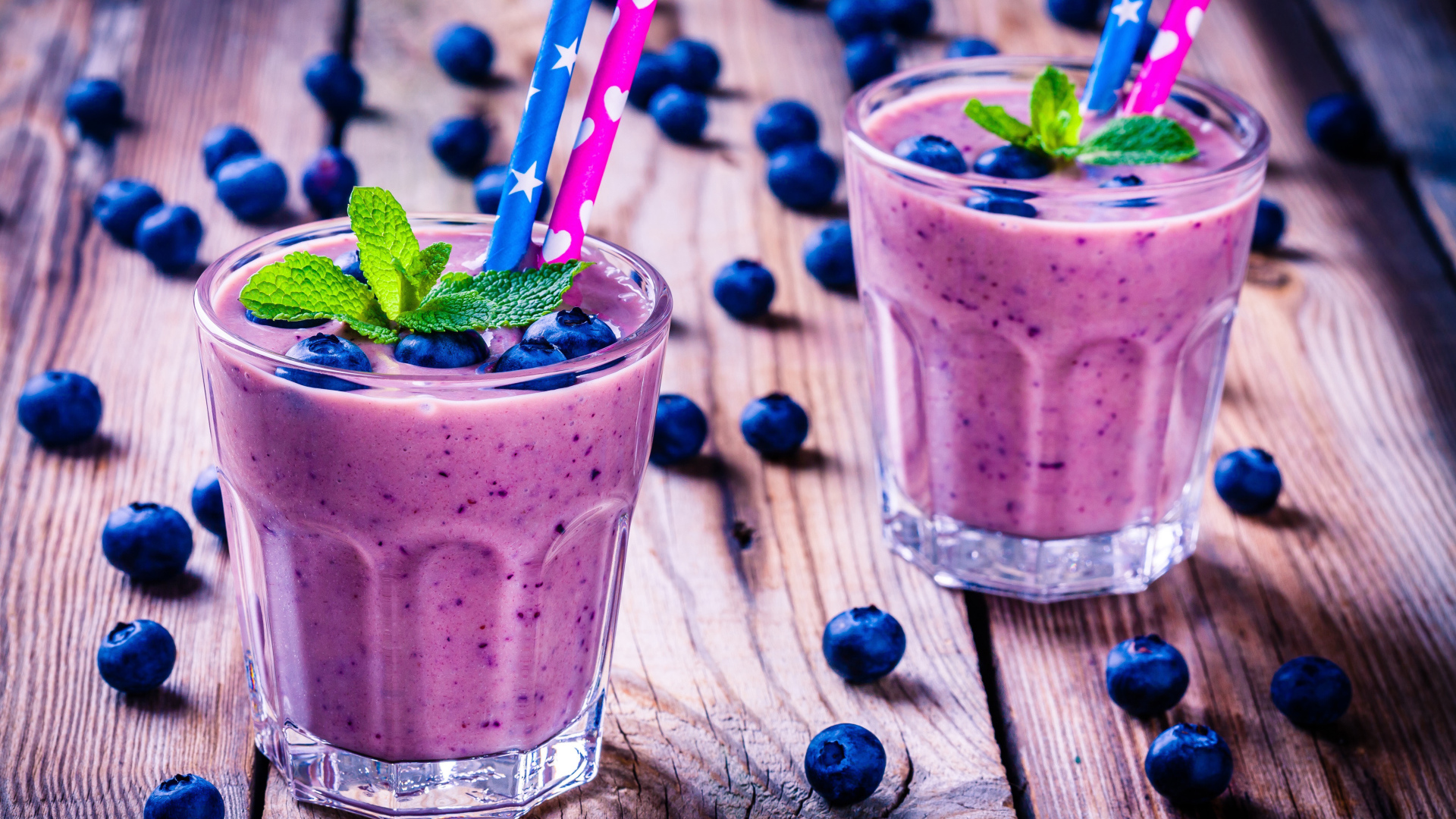 Два стакана черничного коктейля с трубочками