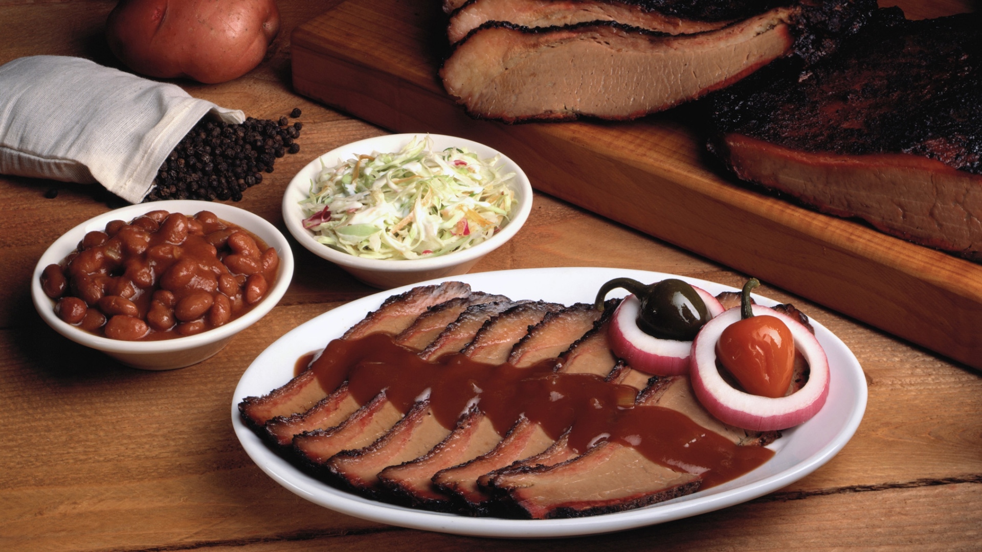 Аппетитные кусочки мяса барбекю на столе с овощами