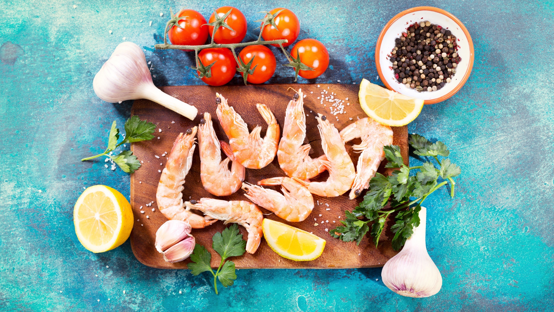 Креветки на разделочной доске с чесноком, лимоном и специями
