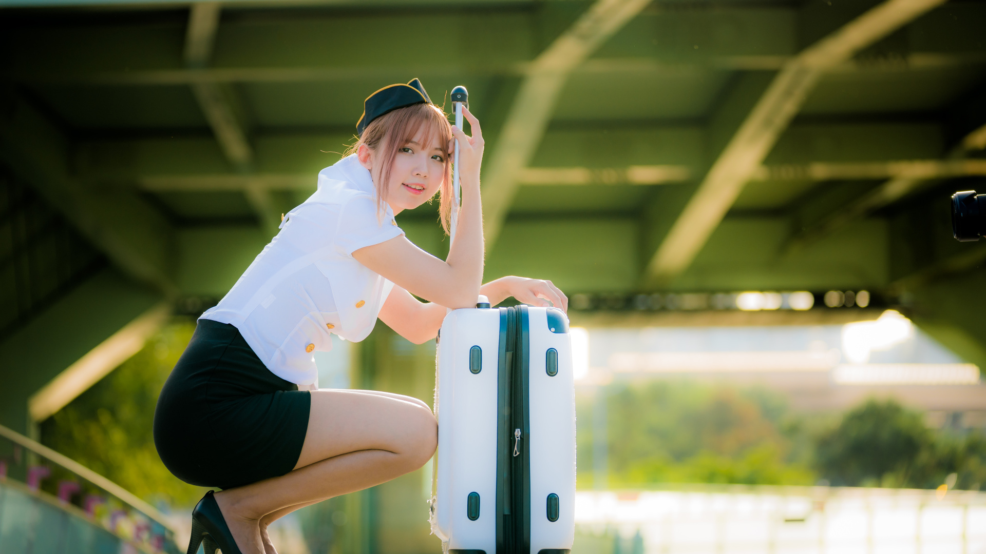 Девушка азиатка стюардесса с чемоданом